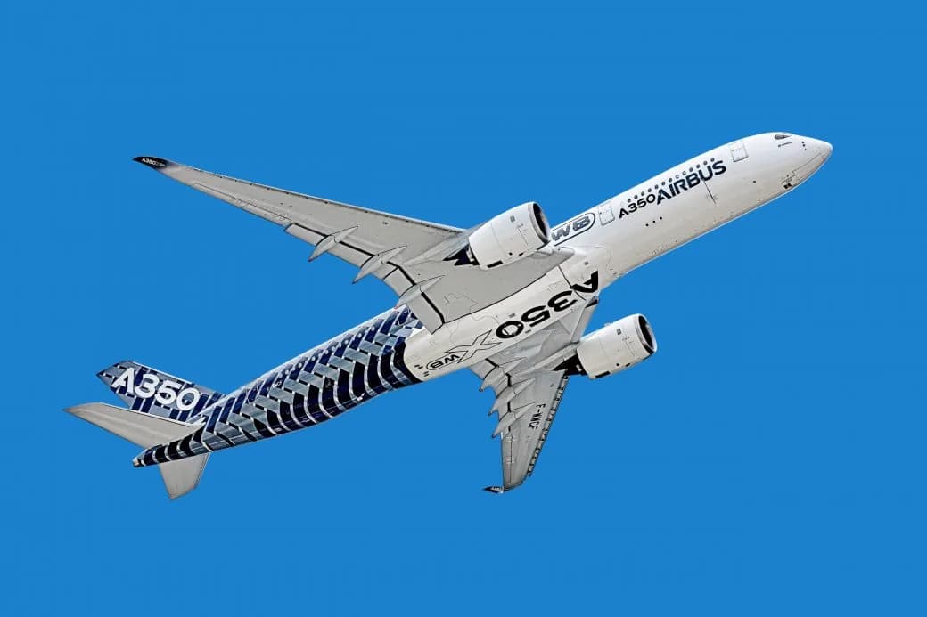 An Airbus A350 aircraft banking against a clear blue sky.